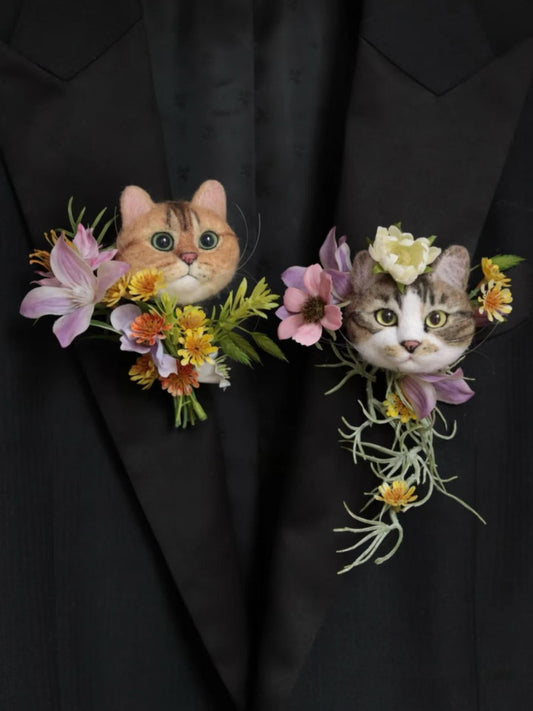 Two cat-shaped floral boutonnieres on a black suit jacket.